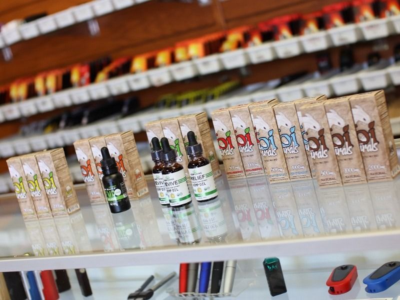 A display case filled with bottles of e liquid and electronic cigarettes.