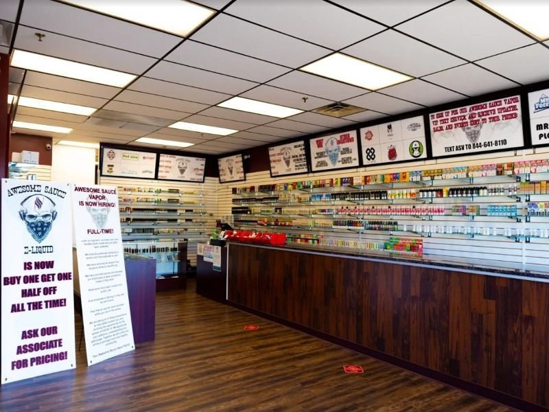 The inside of a vape shop with a sign that says `` is now buy one get one all the time ''.