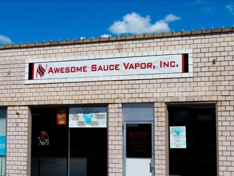 A brick building with a sign that says awesome sauce vapor inc.