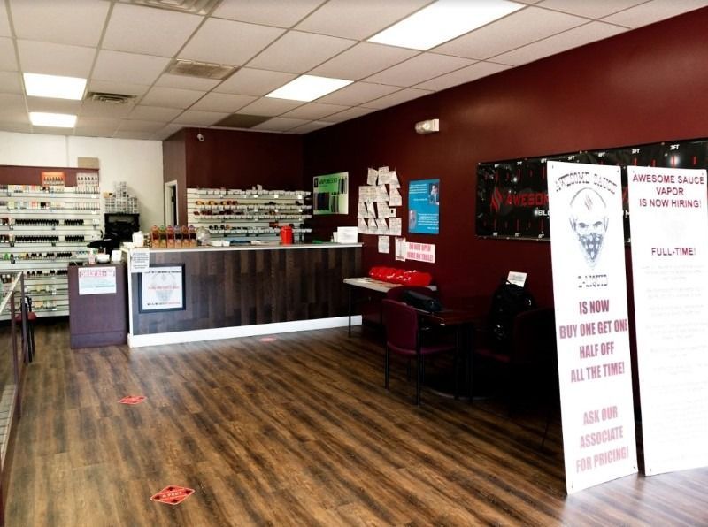 A large room with a wooden floor and a counter in a store.
