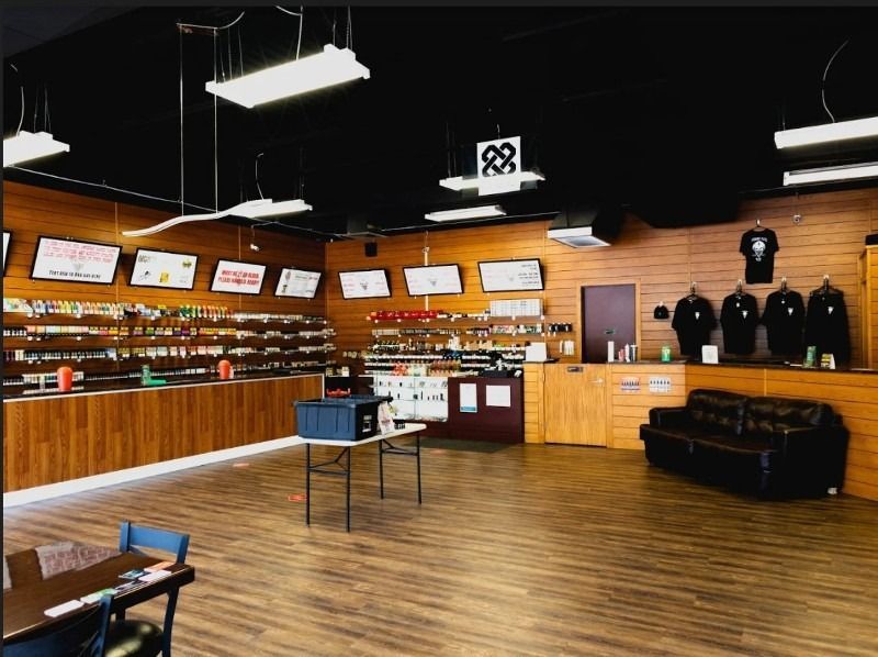 The inside of a store with tables and chairs and a couch.