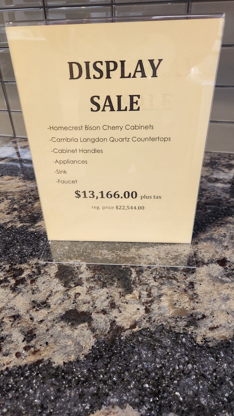 A display sale sign is sitting on a counter.