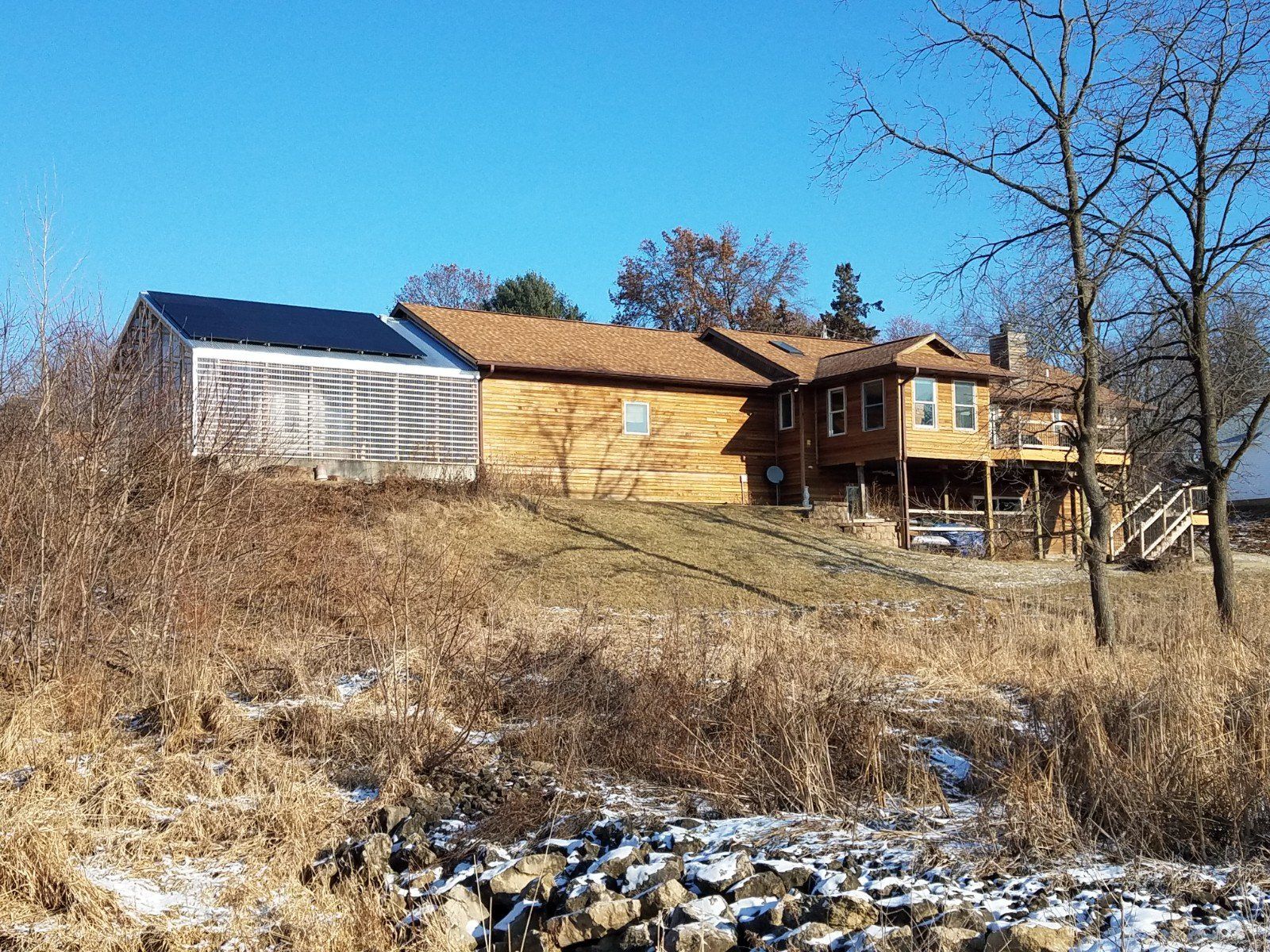 A large house is sitting on top of a hill in the middle of a field.