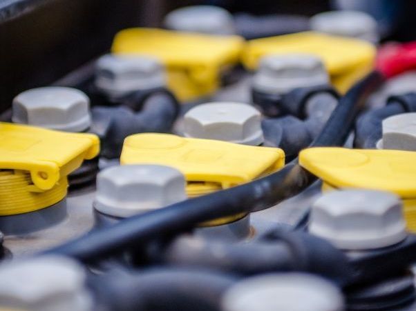 A close up of a battery with yellow caps and wires