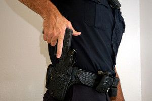 A police officer pulling out his gun from the holster