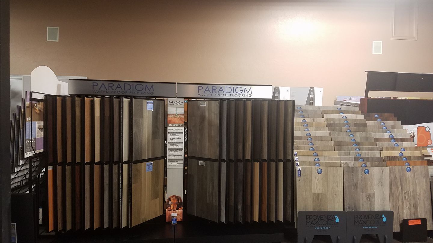 Flooring samples displayed in a store, showcasing various wood and tile textures and colors.