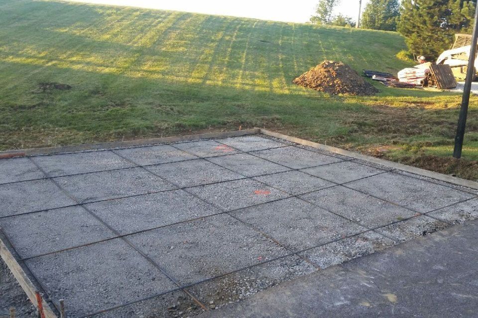 Concrete slab with rebar grid, set in a yard, awaiting pour.