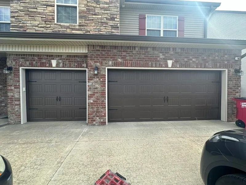 Two brown garage doors, one single and one double, on a brick and stone house. Concrete driveway.