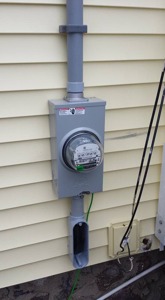 A meter is attached to the side of a house.