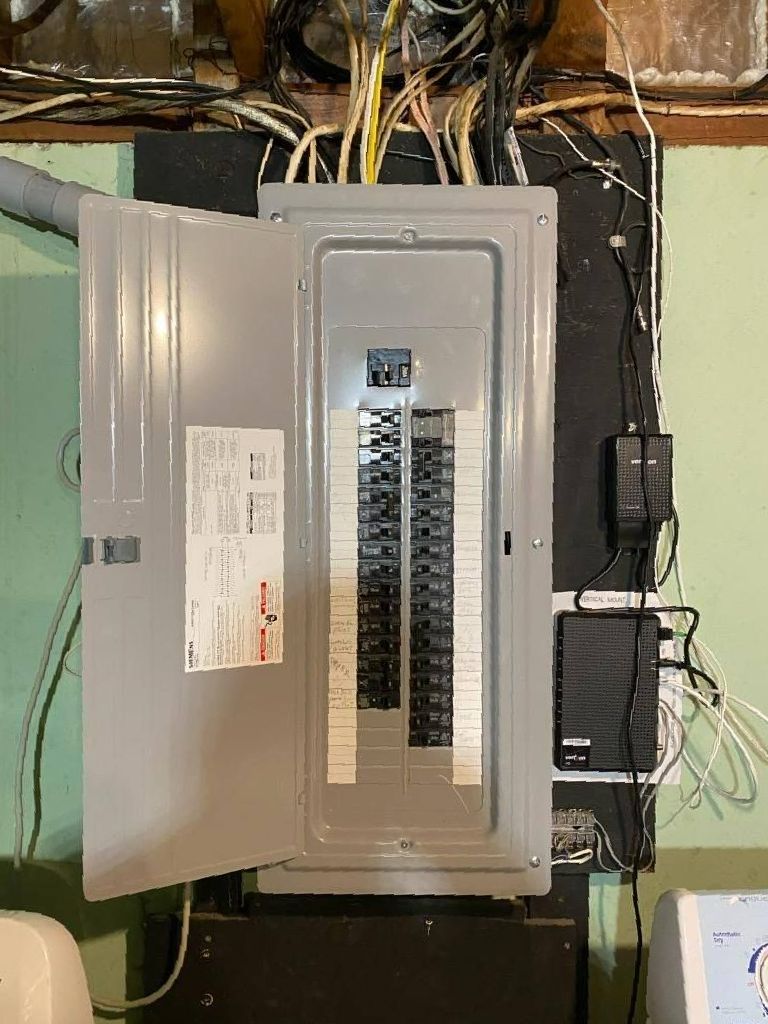 A electrical box is hanging on a wall with the door open.