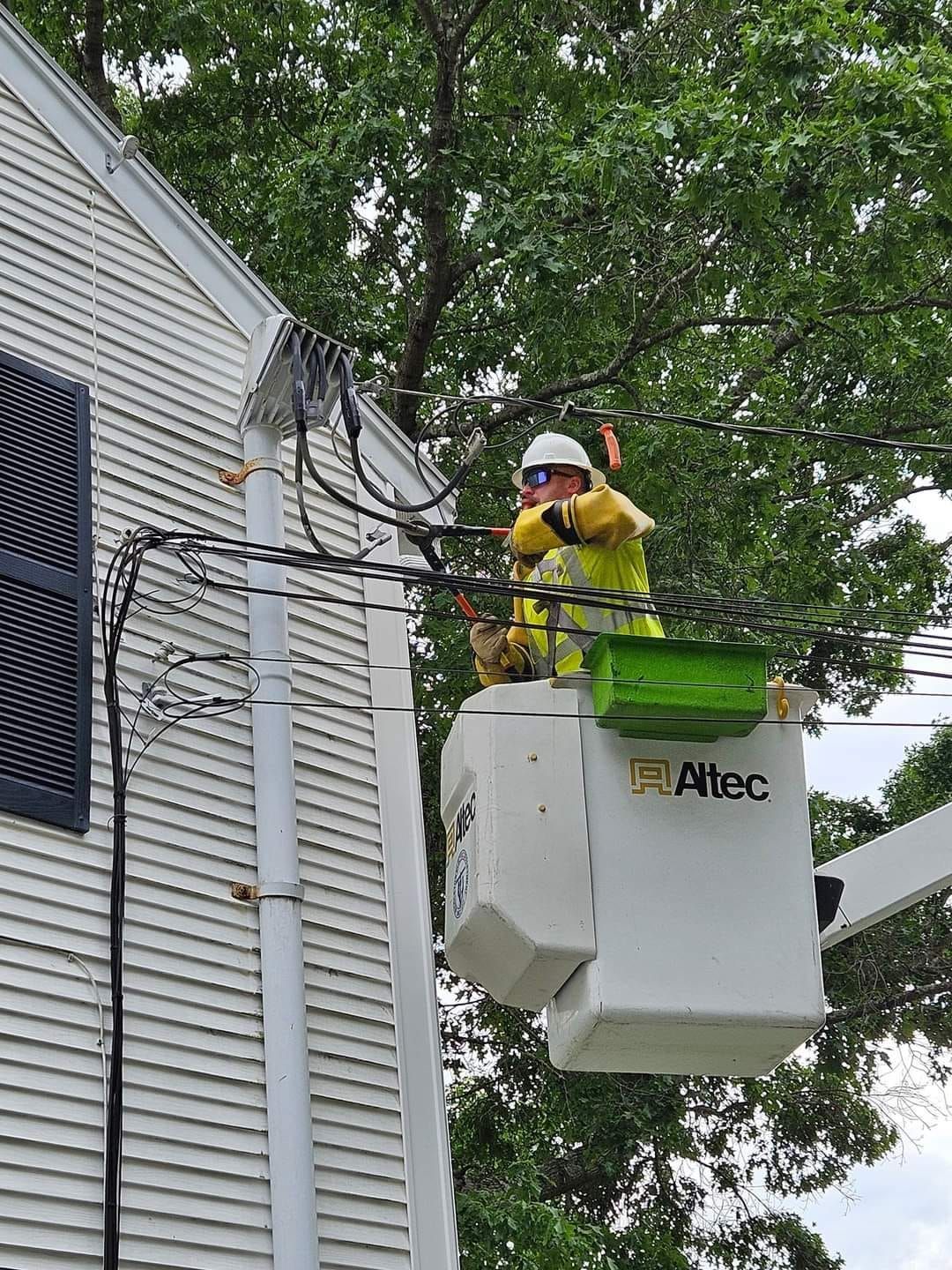 A man is working on a power line in a bucket.