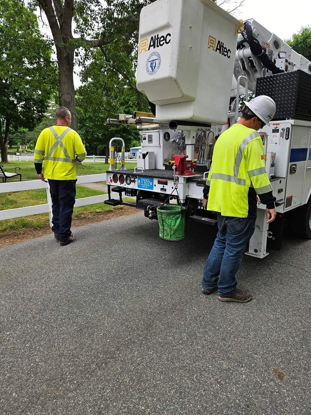 Two men are standing next to a truck on the side of the road.