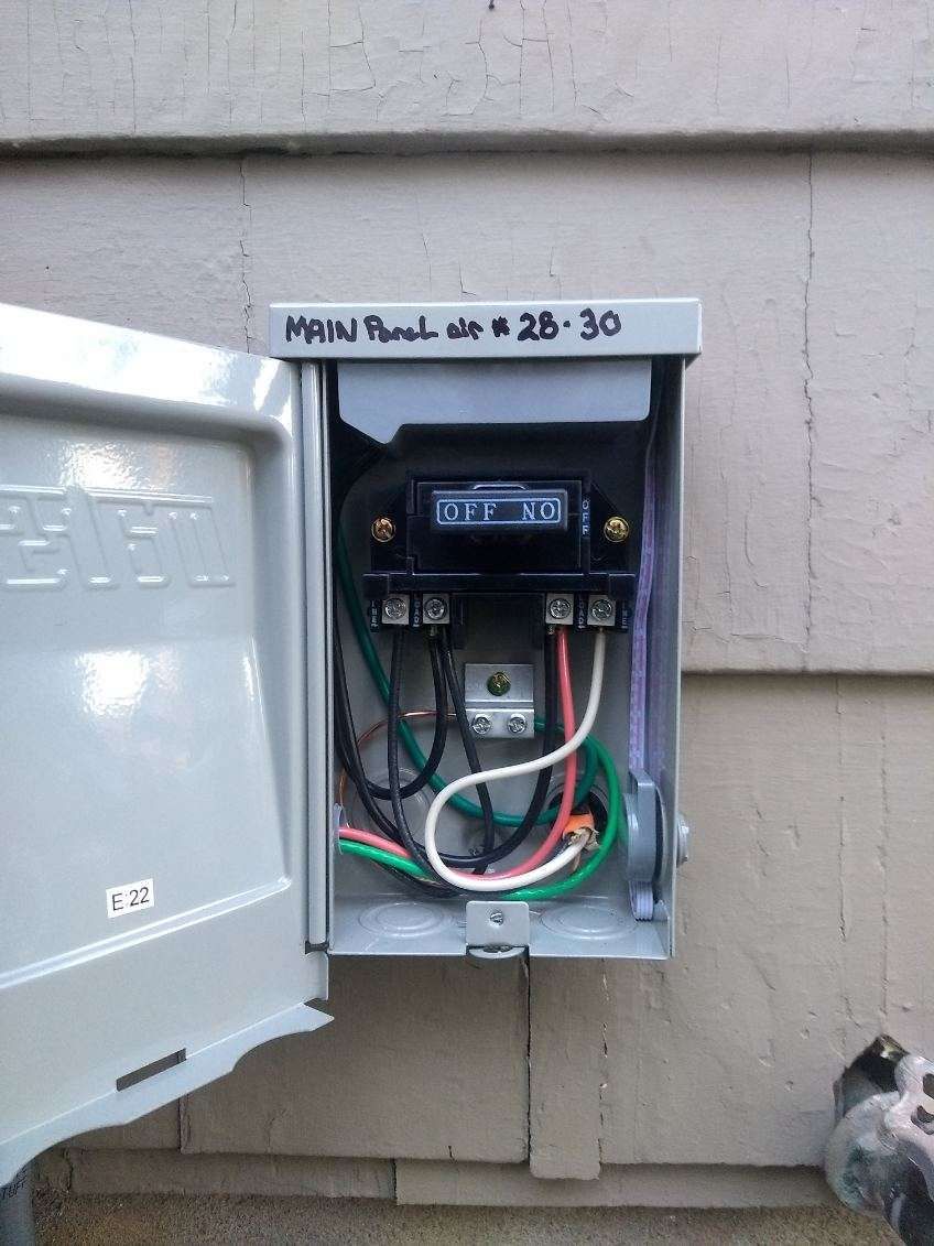 A box with wires coming out of it is attached to a wall.