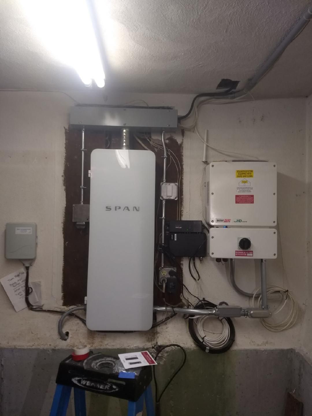 A white box is sitting on a ladder in a room next to a wall.