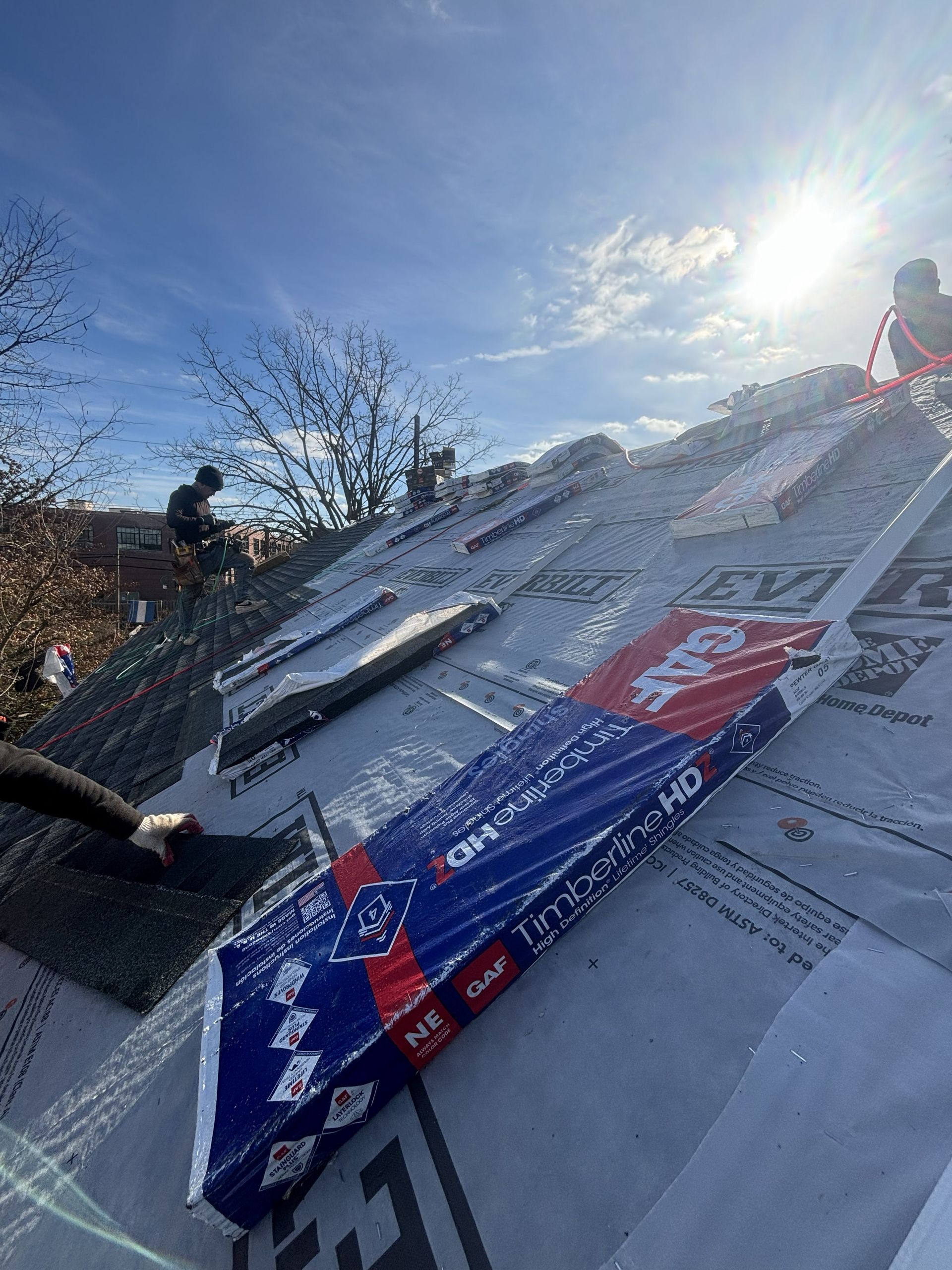Ski jump ramp under bright sun with banners and workers on the slope