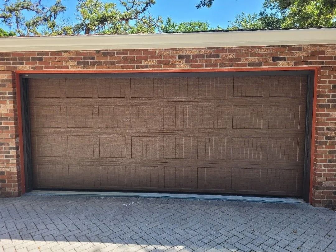 Brown garage door in a red brick building.