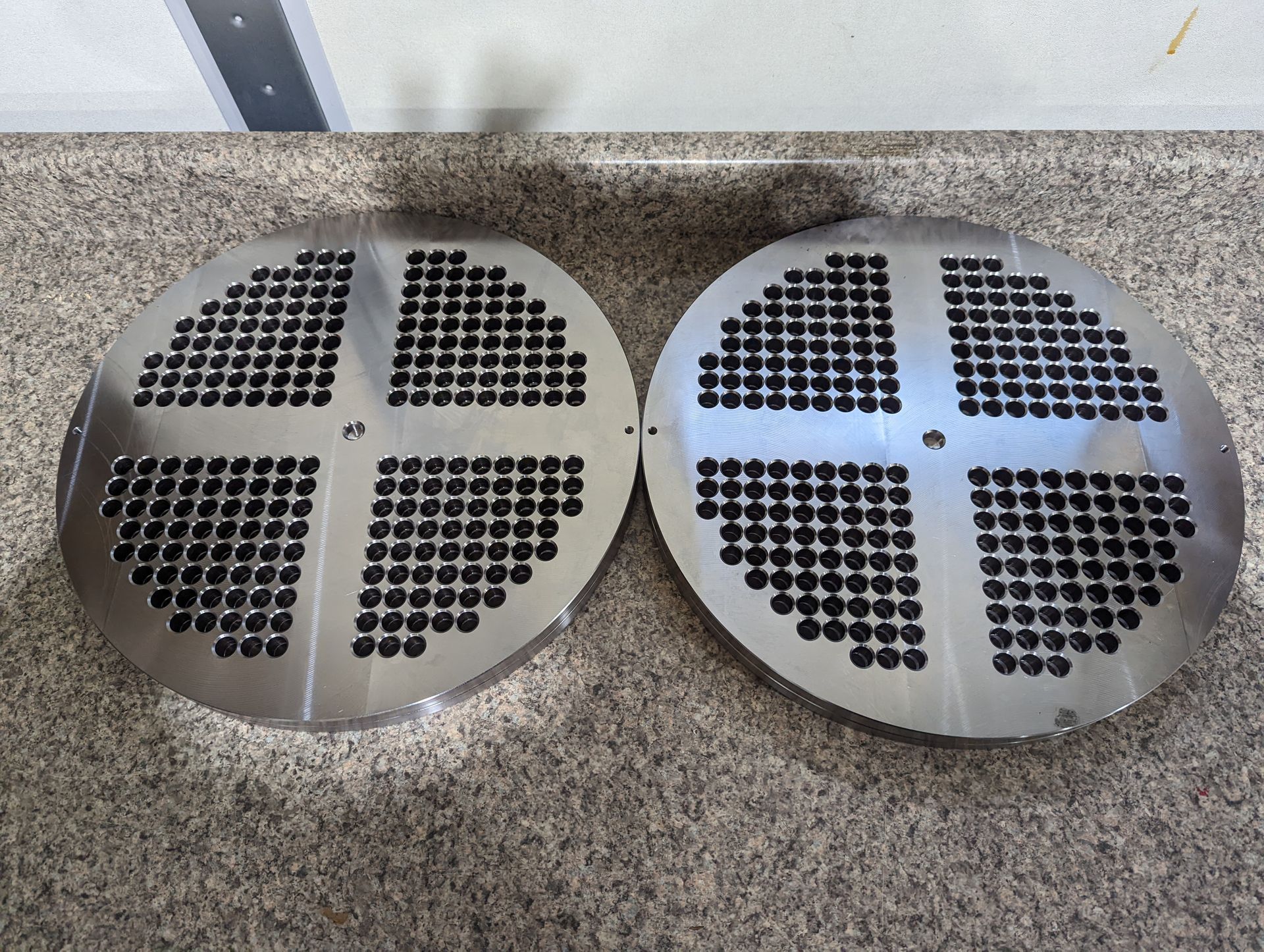 Two stainless steel circles with black dots on them.