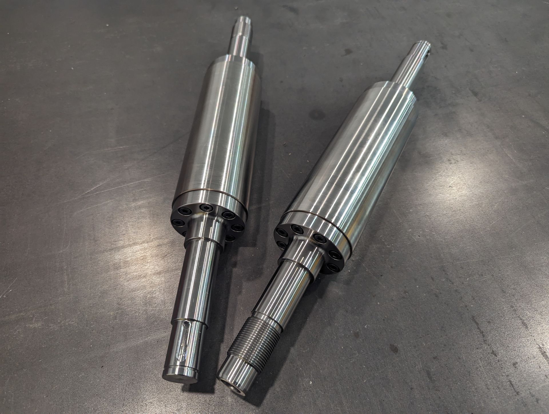 Two metal cylinders are sitting next to each other on a table.