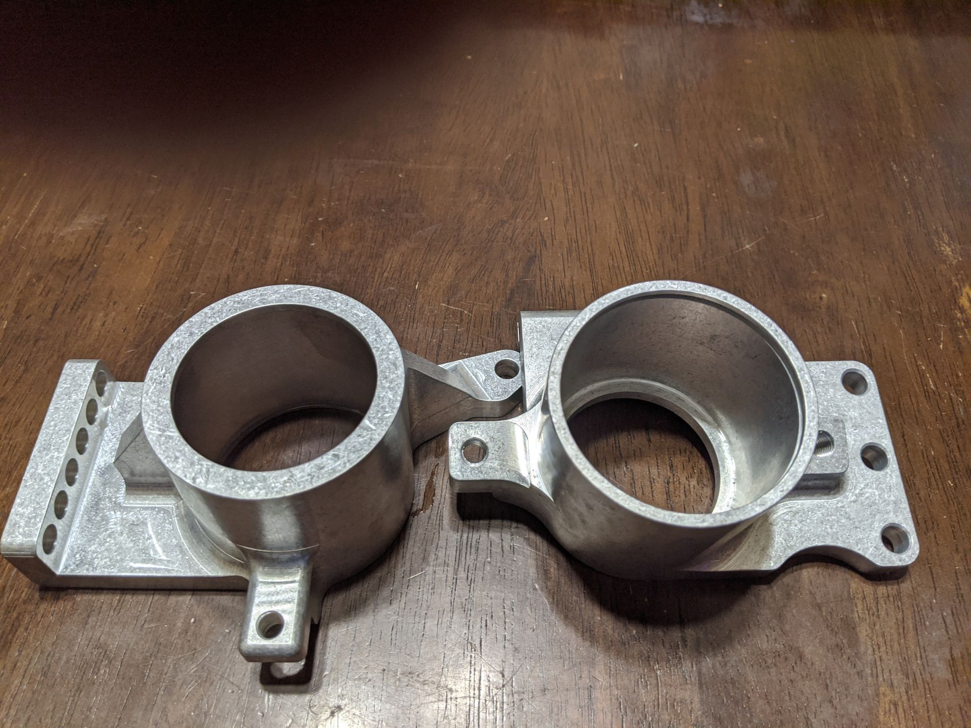 Two pieces of metal are sitting on top of a wooden table.