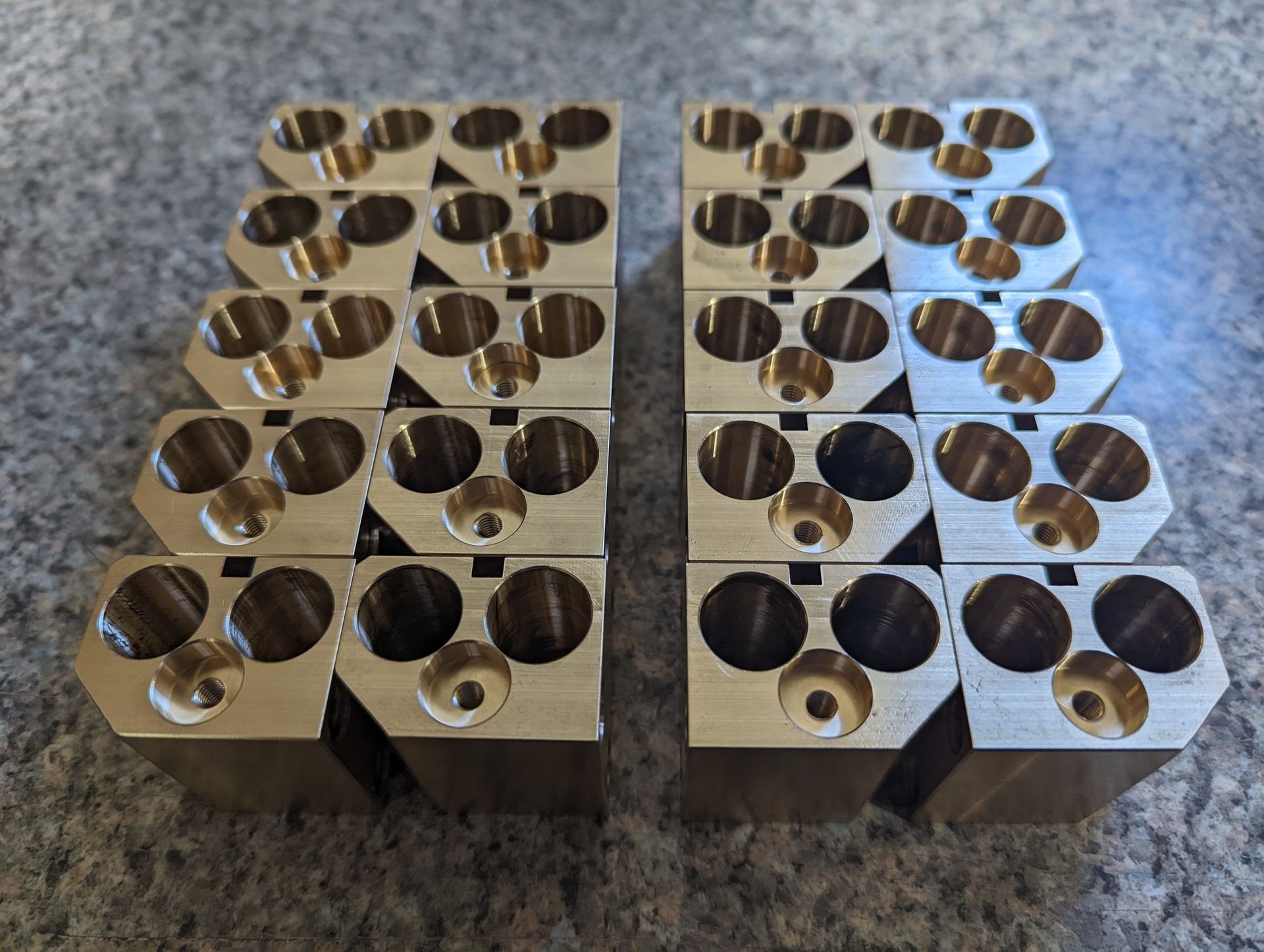 A group of metal blocks with holes in them are stacked on top of each other on a table.