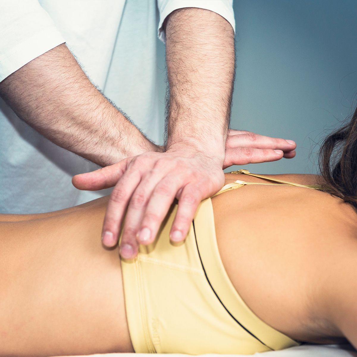 A man is giving a woman a massage on her back