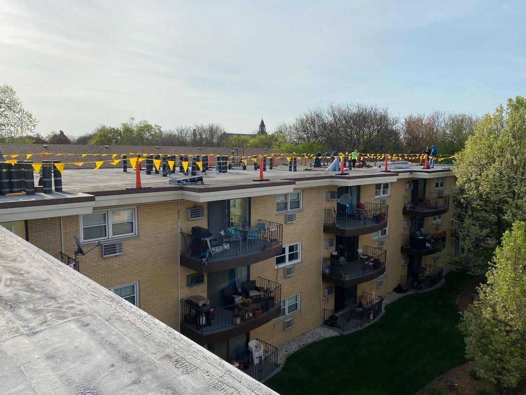 Apartment building roof with numerous construction cones in preparation for roof repair.