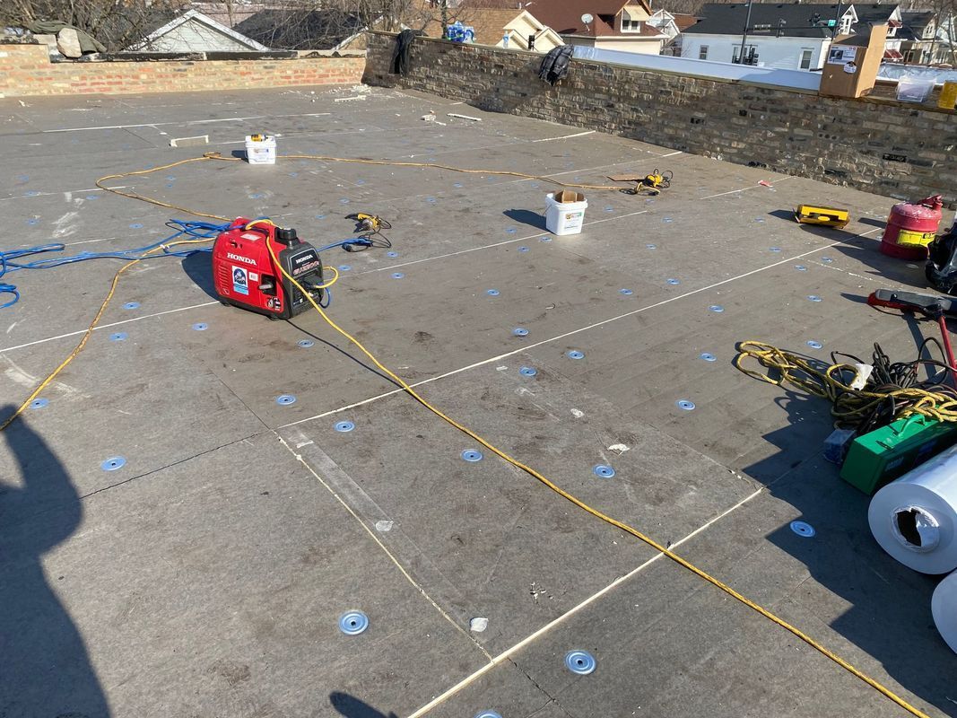 Rooftop work: red generator, buckets, yellow cords, insulation rolls, dotted lines, and tools scattered across a dark roof.
