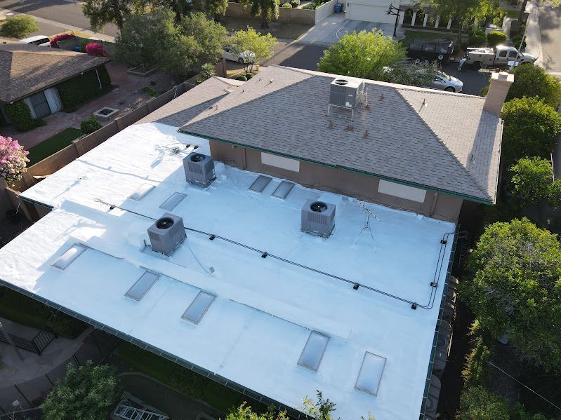 An aerial view of a house with a white roof.