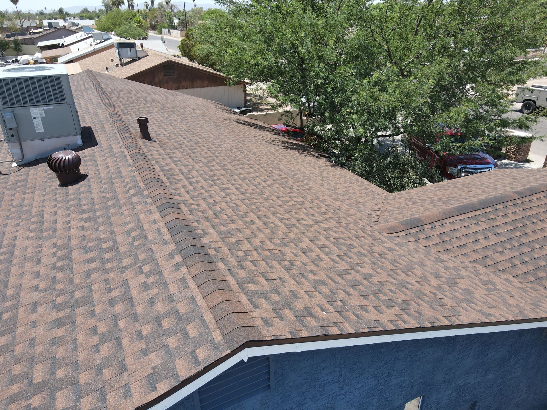 An aerial view of a roof with a pool in the background.