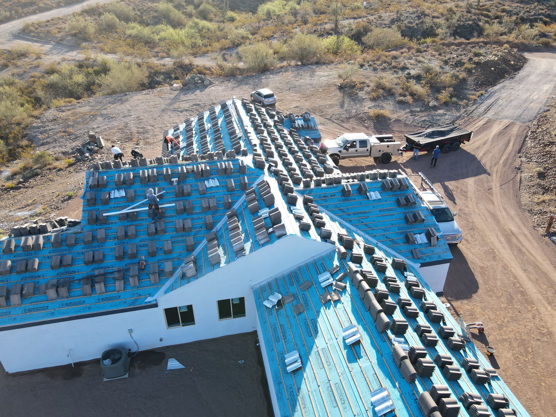 An aerial view of a building under construction with a blue roof.