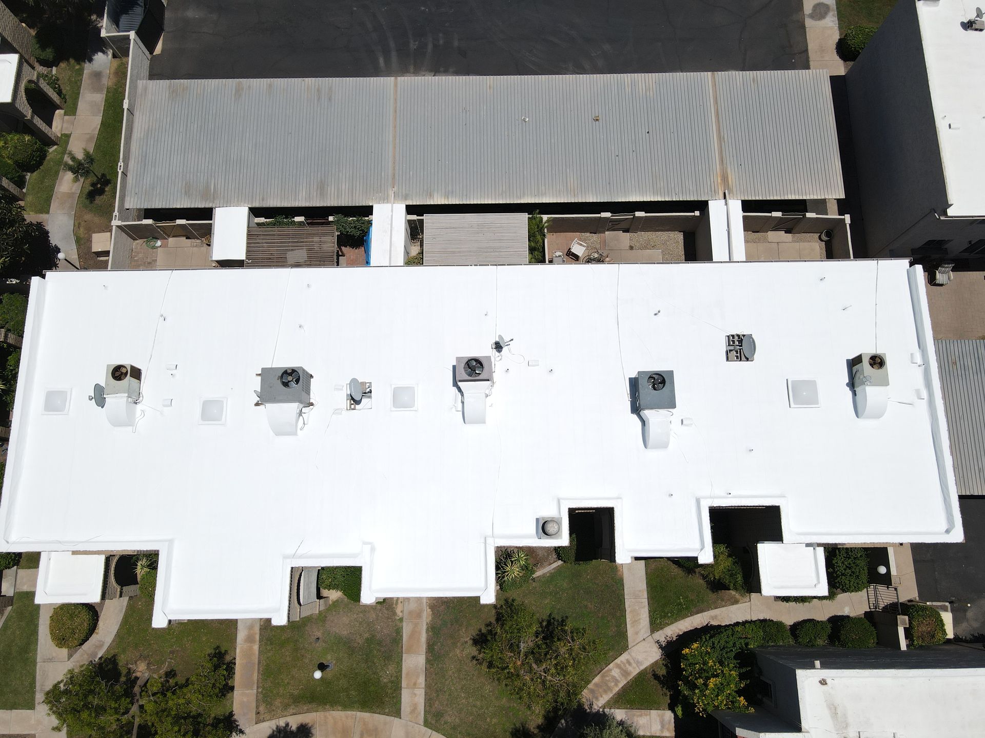 An aerial view of a building with a white roof.