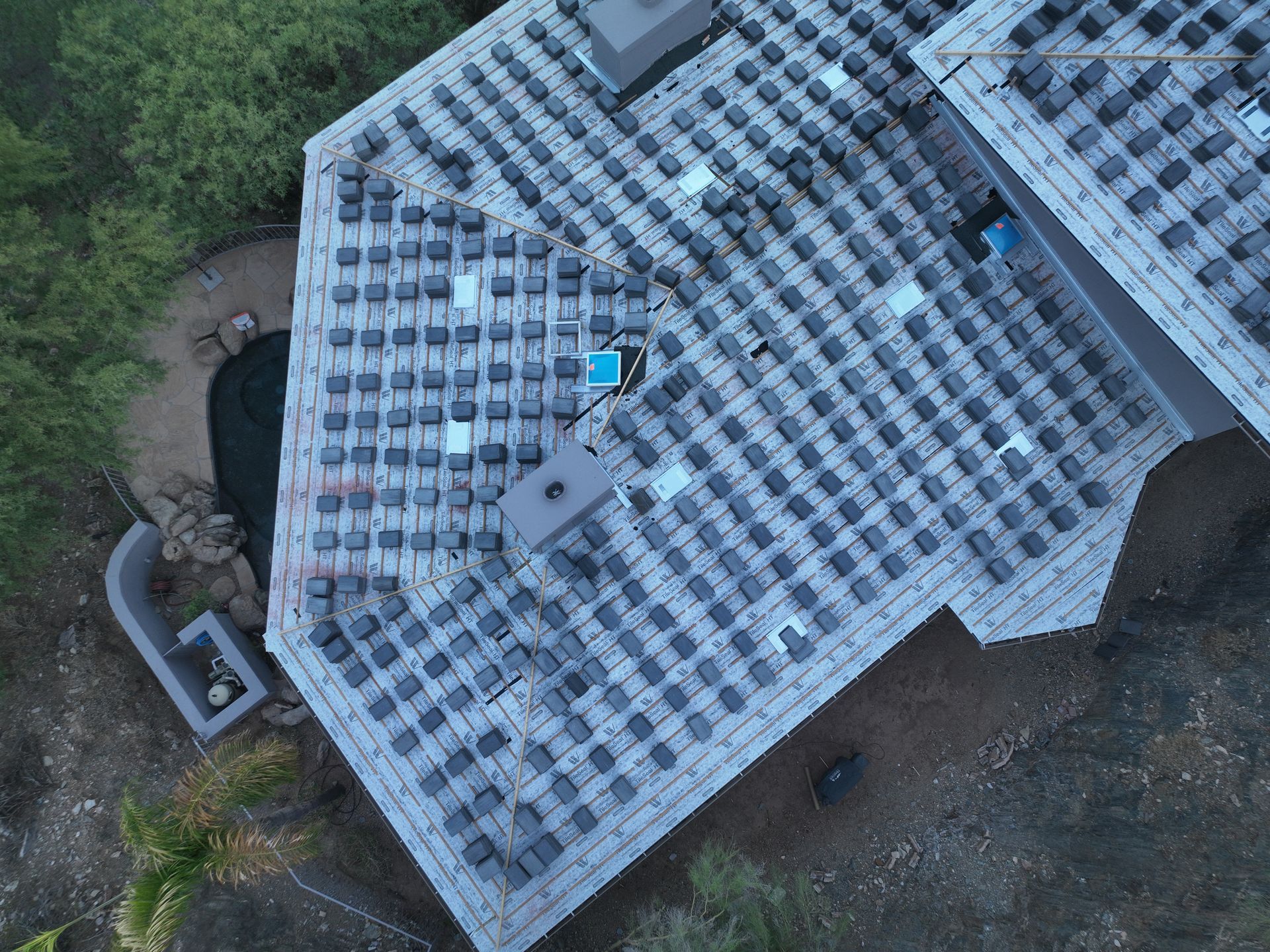 An aerial view of a house with a lot of solar panels on the roof.