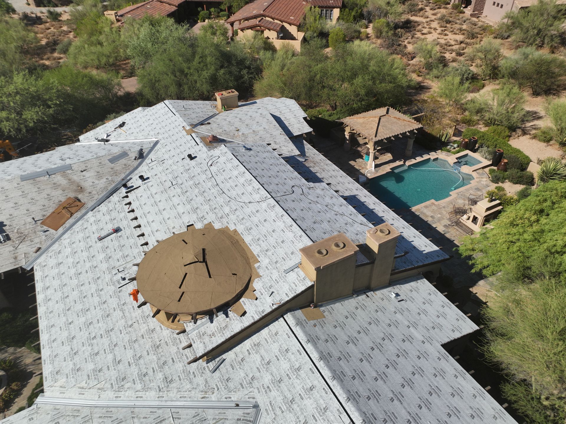 An aerial view of a large house with a pool in the background.