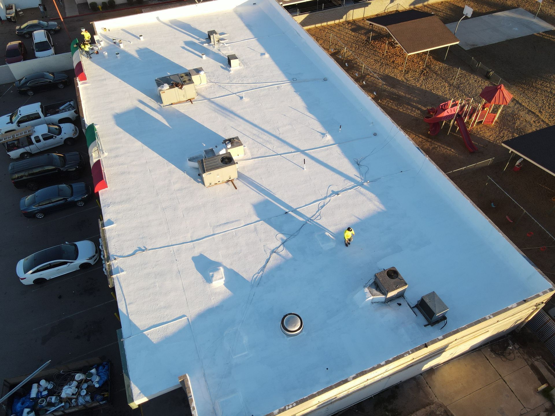 An aerial view of a large building with a white roof.