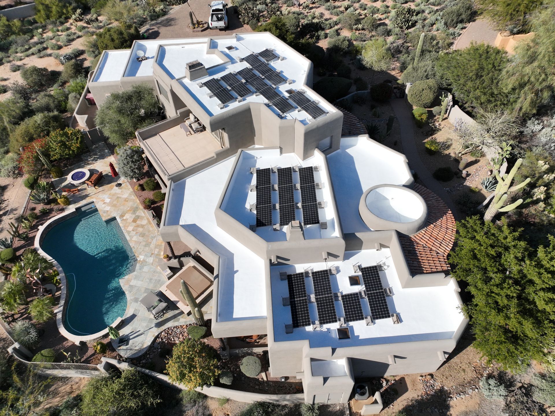 An aerial view of a large house with solar panels on the roof.