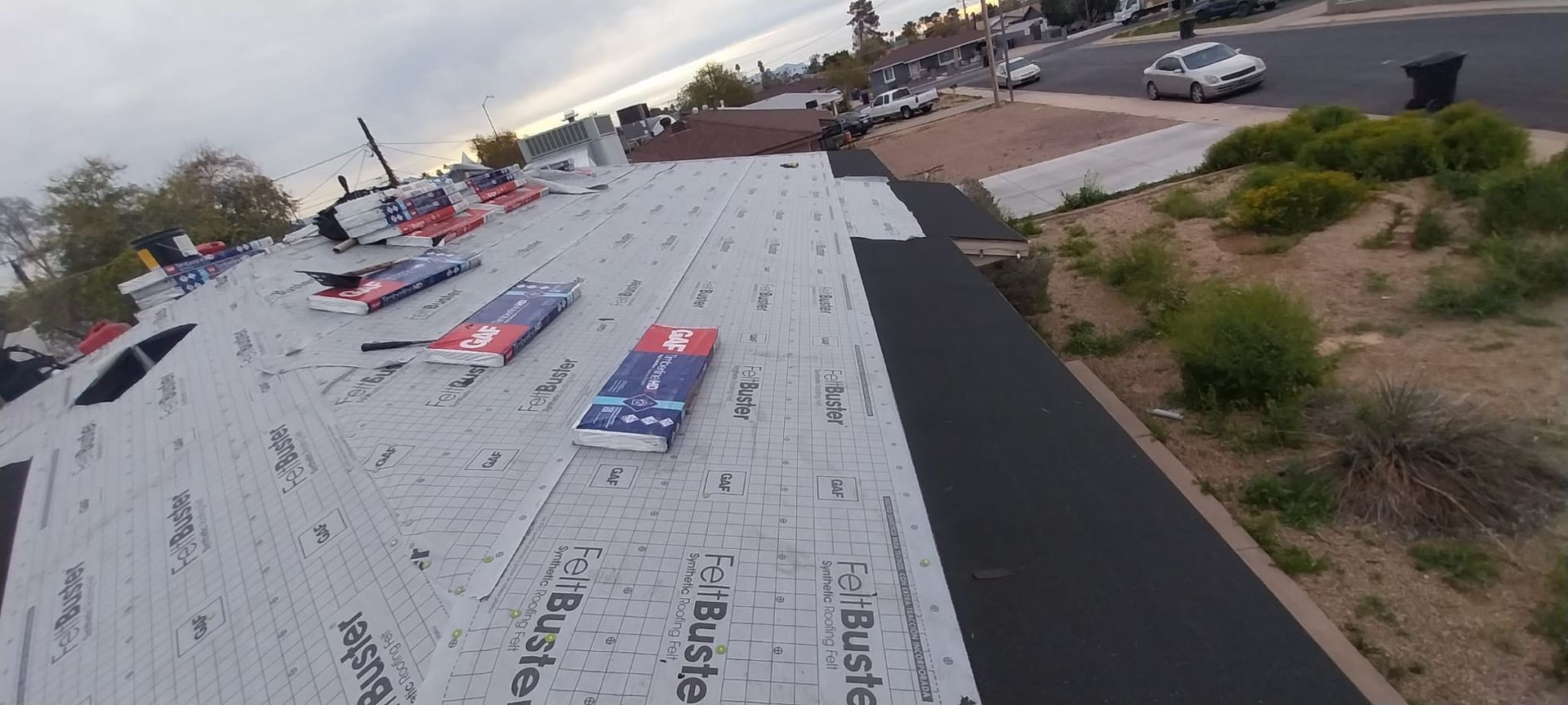 A roof with a lot of shingles on it is being installed.