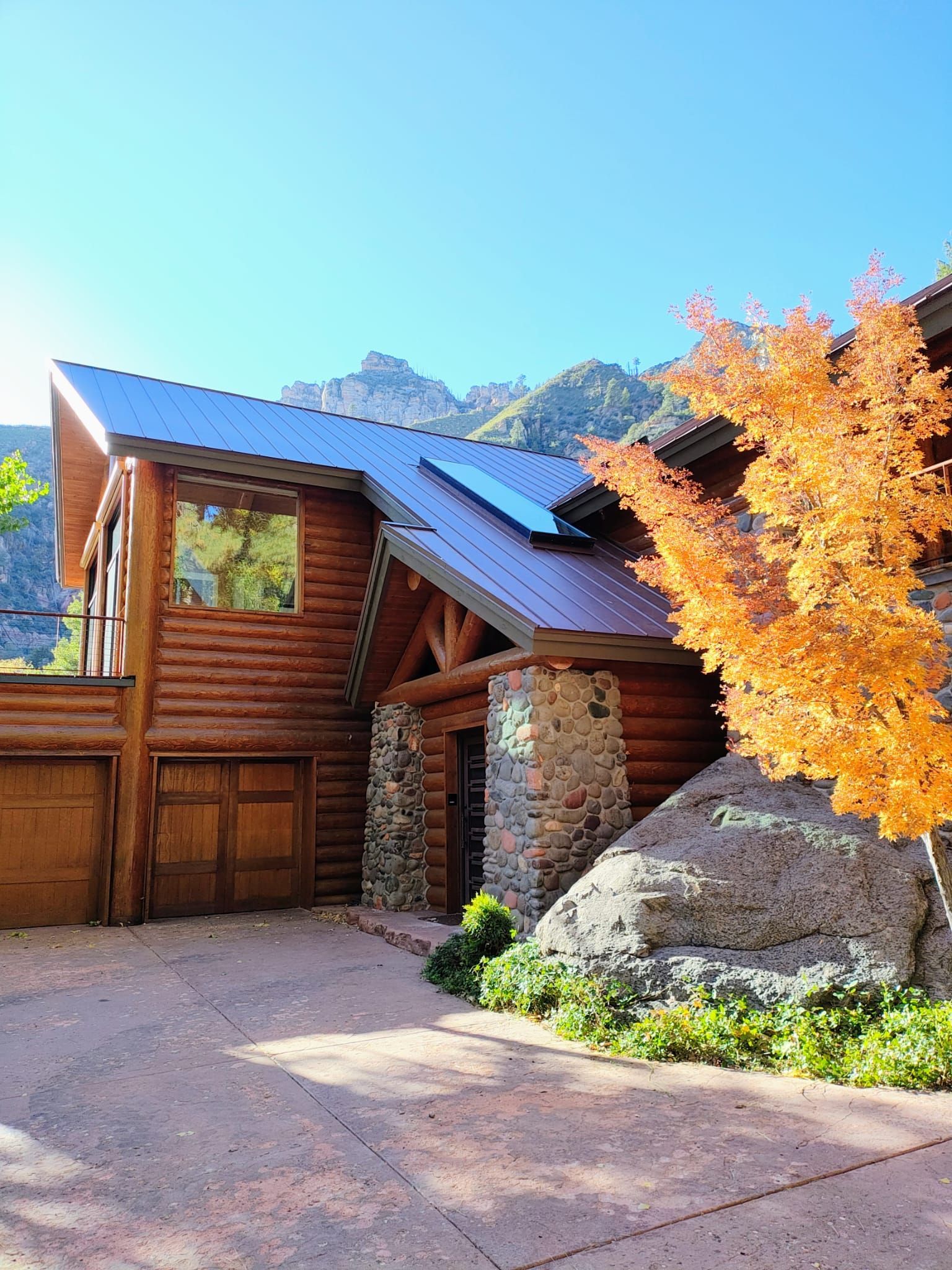A large log cabin with metal roofing.