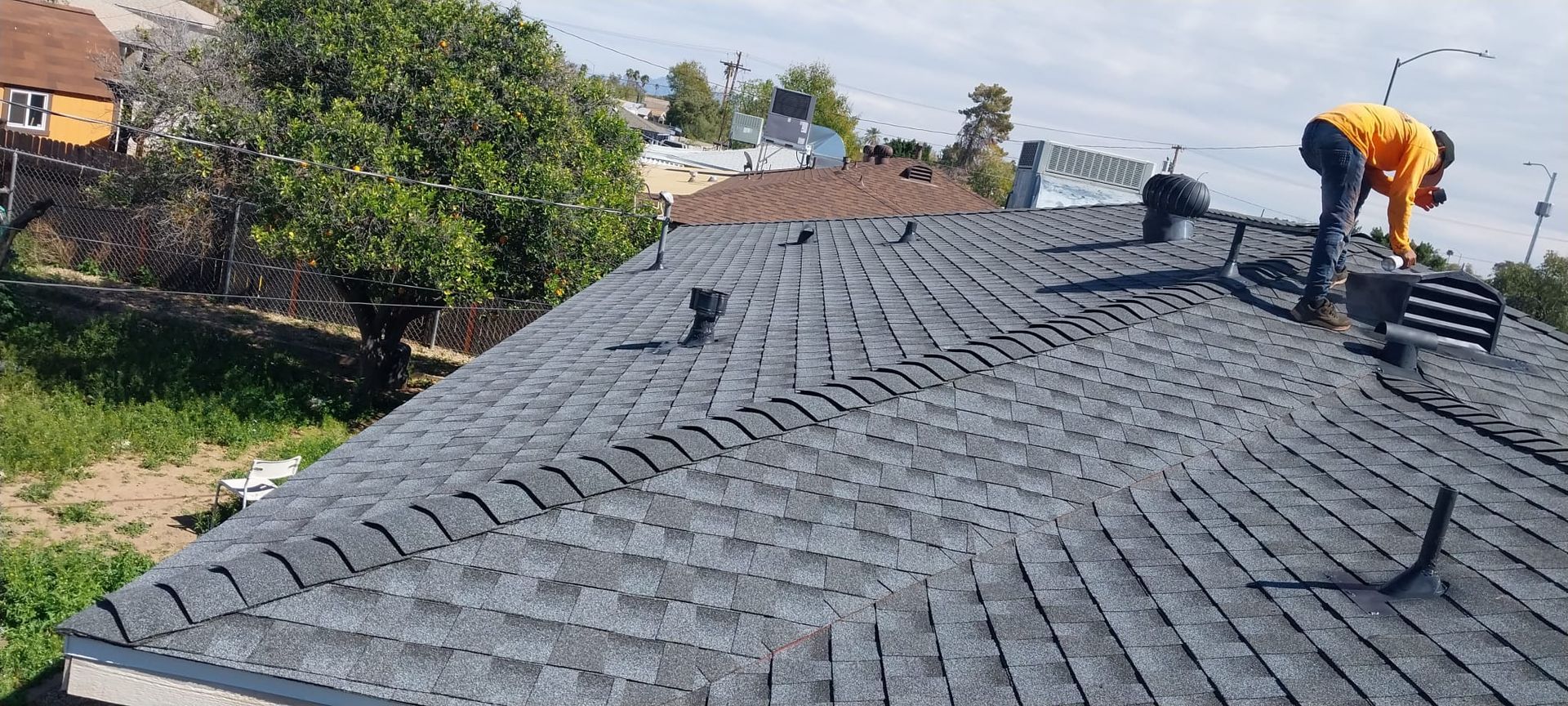 A man is working on the roof of a house.