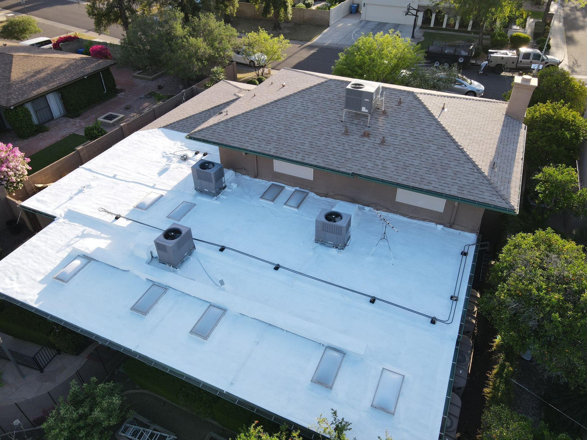 An aerial view of a house with a white roof.