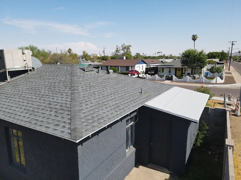 An aerial view of a house with a new roof in a residential area.