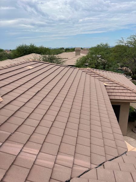 A house with a tiled roof and a blue sky in the background.