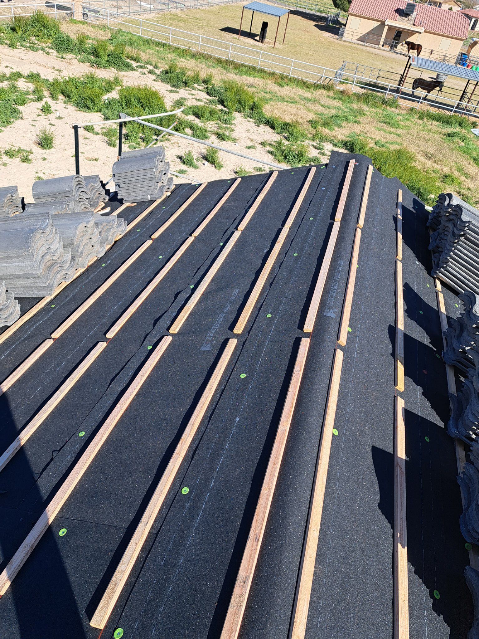 A black roof with wooden beams is being built.