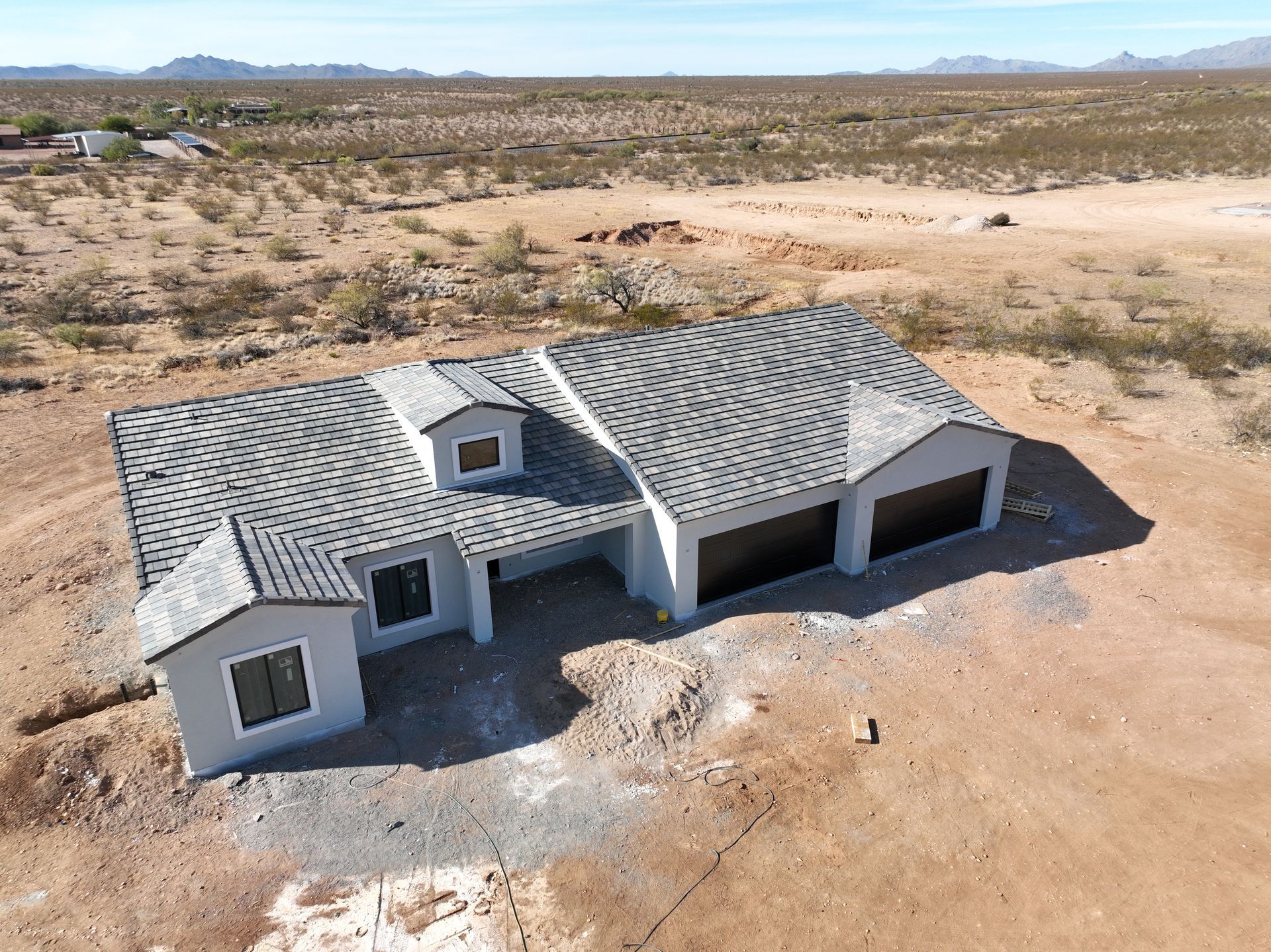 An aerial view of a house in the middle of a desert.
