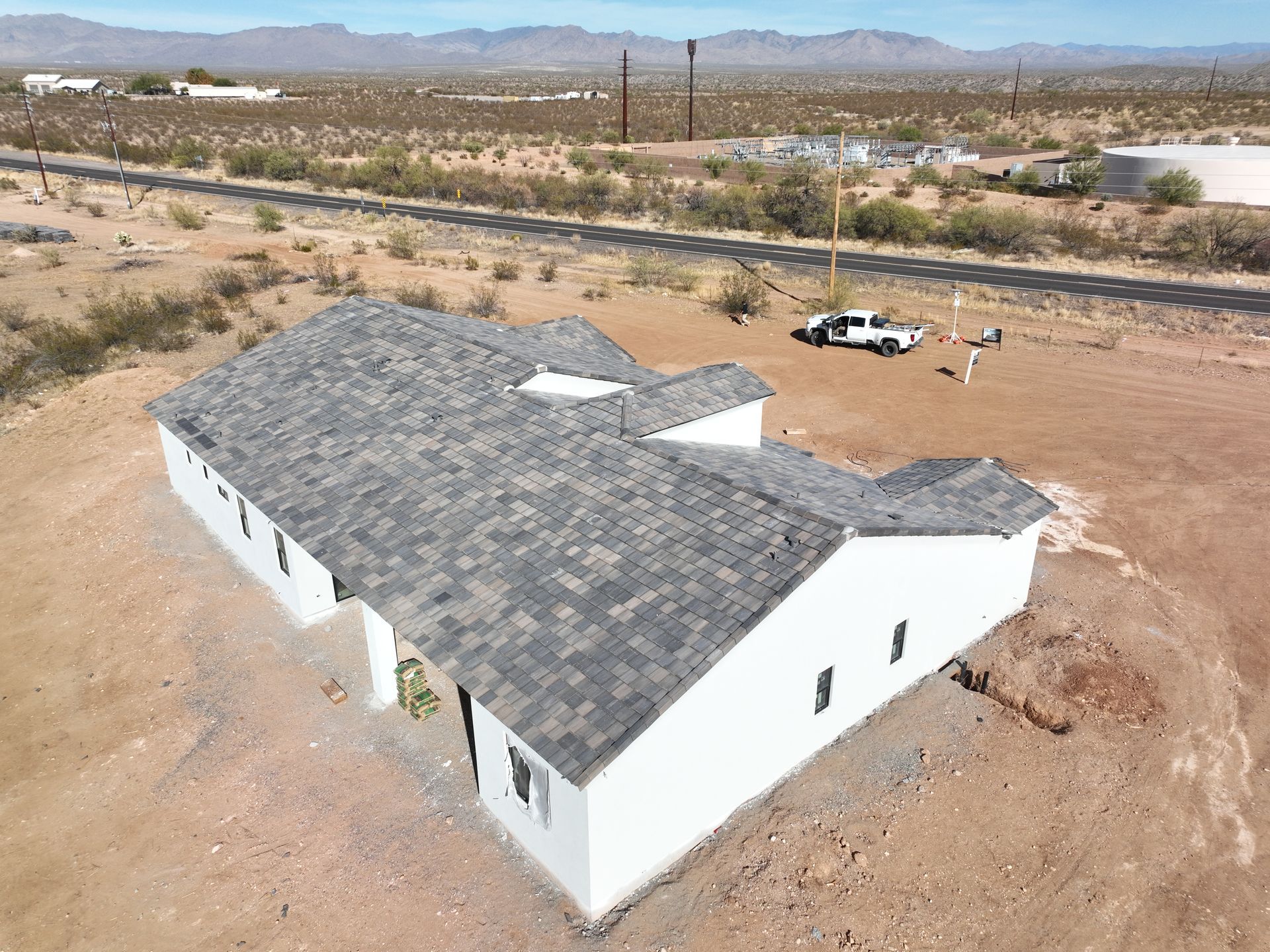 An aerial view of a white house in the middle of a desert.