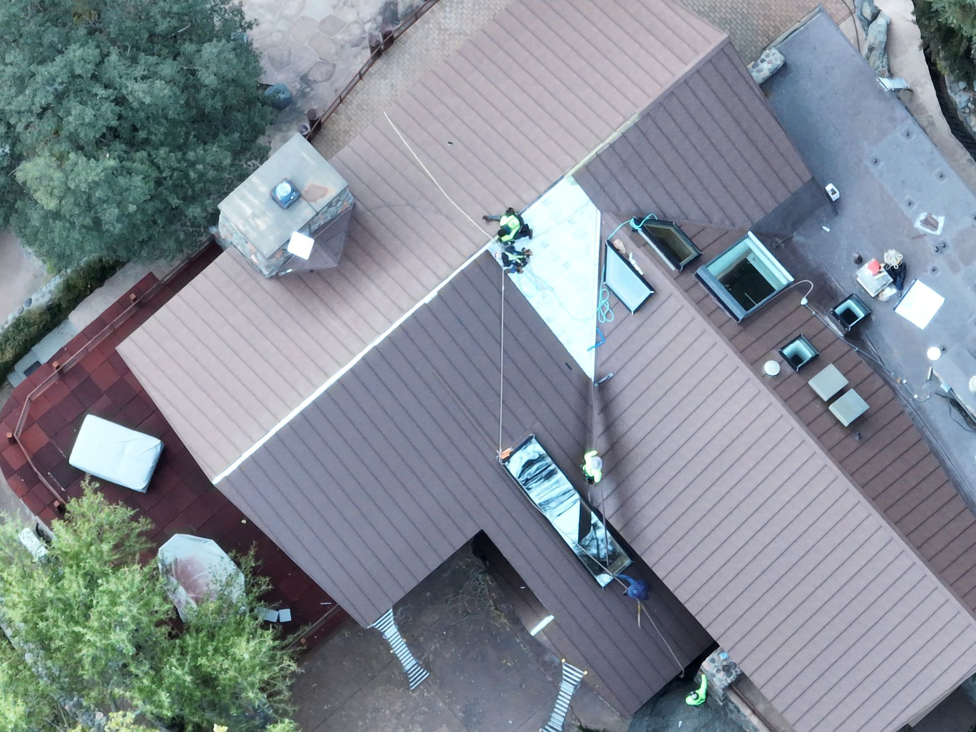 An aerial view of a house with workers on the roof.