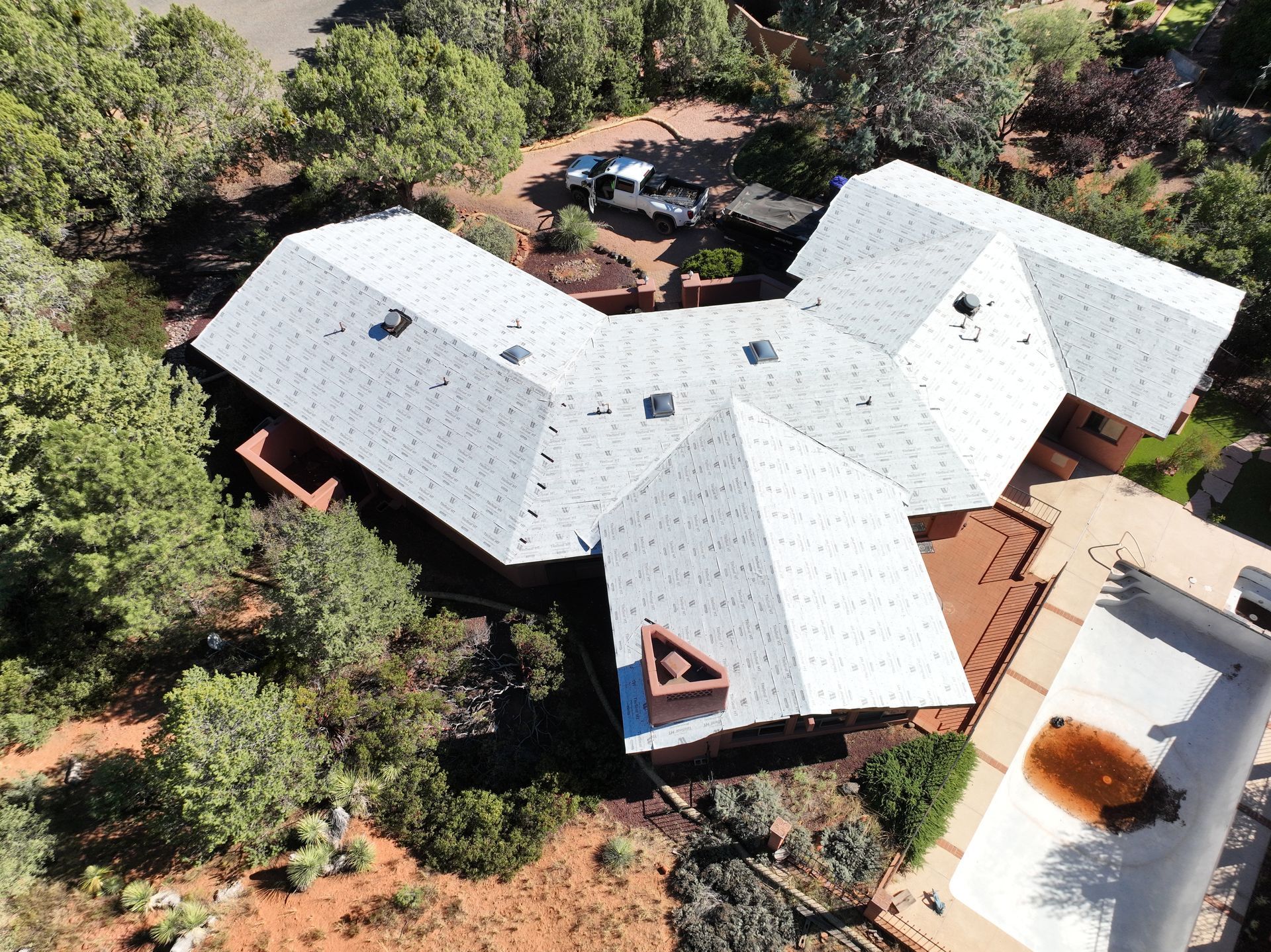 An aerial view of a house with a white roof.