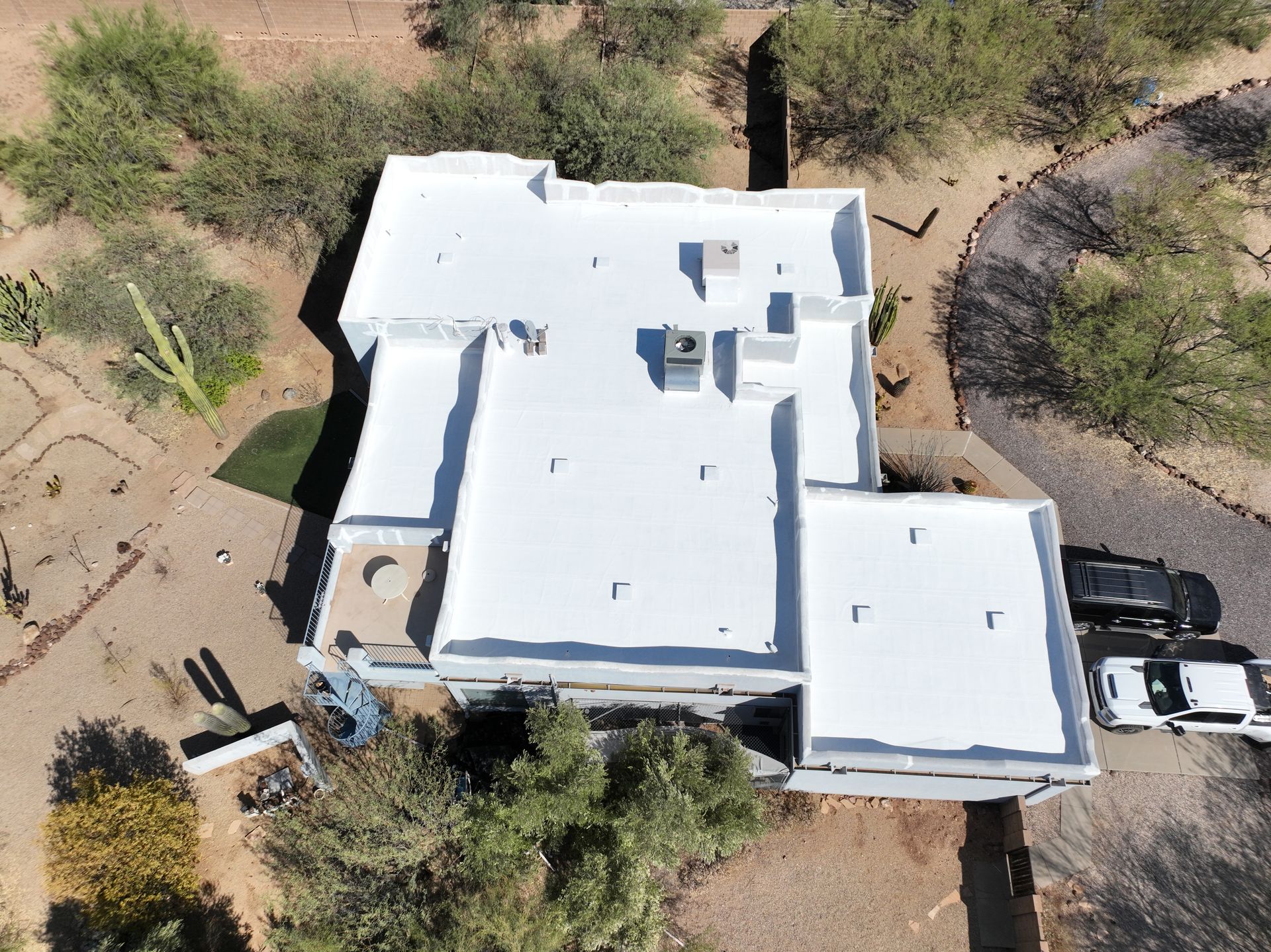 An aerial view of a house with a white roof.