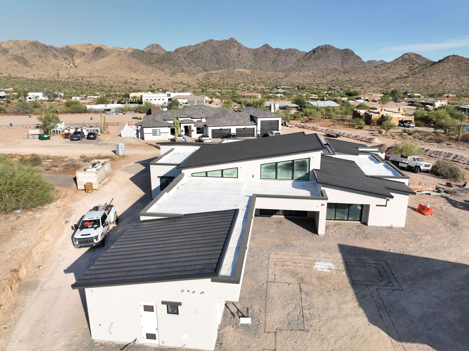 An aerial view of a house under construction with mountains in the background.