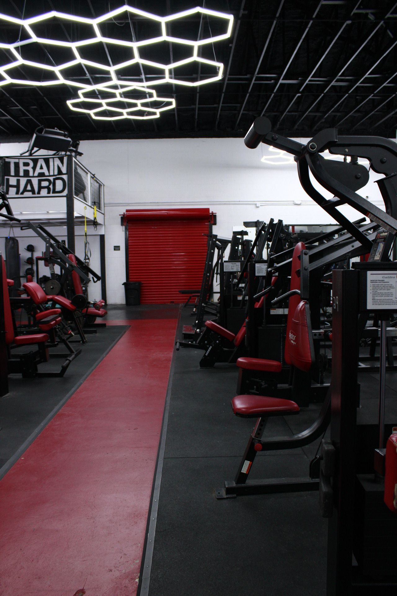 A gym with a sign that says train hard on it