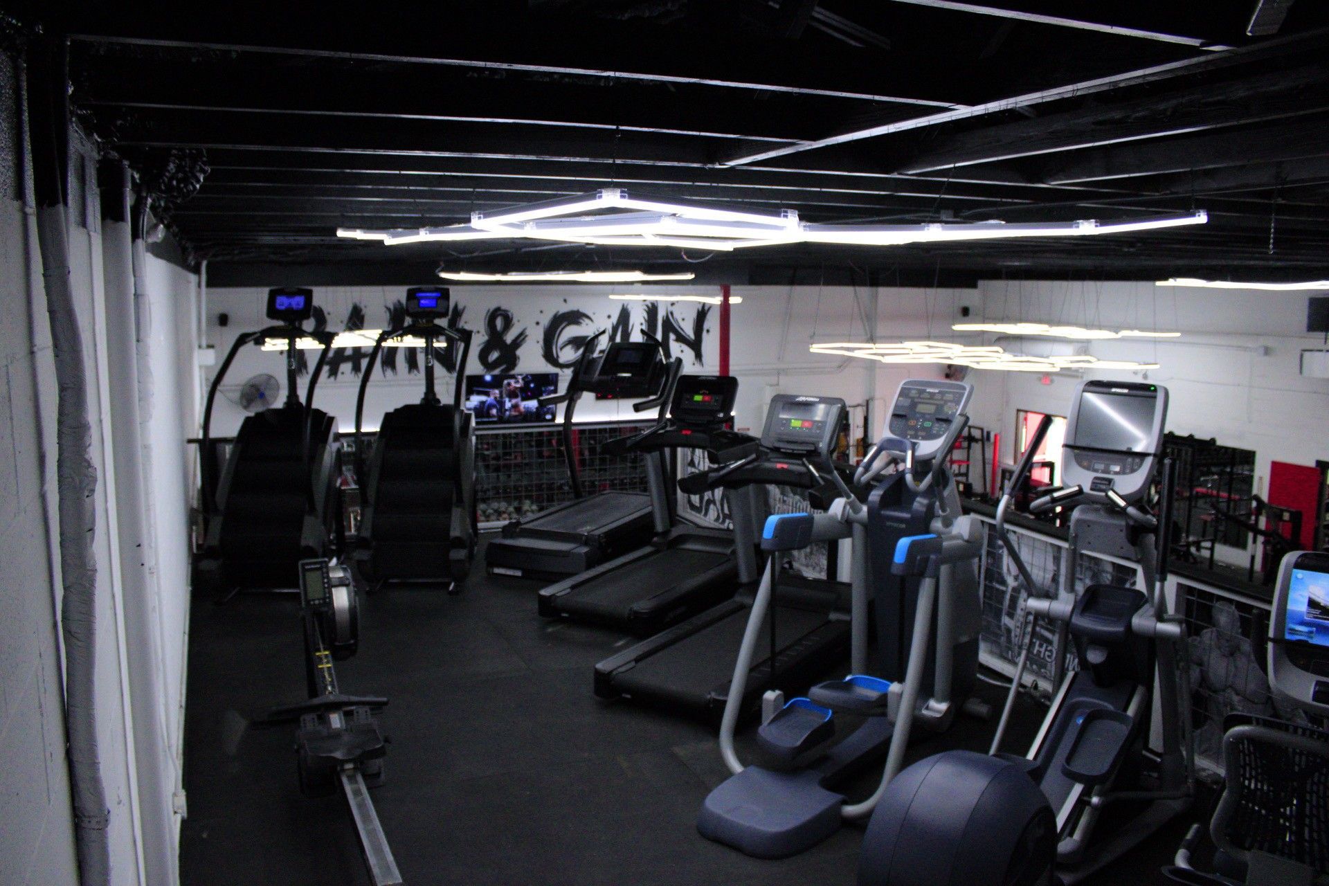 A gym with a lot of treadmills and exercise bikes